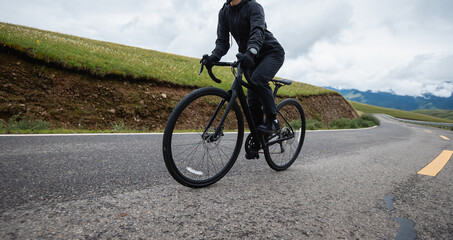 Naklejka premium Riding bike on grassland mountain top trail