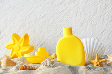 Beautiful composition with sand, sunscreen and beach accessories for children on white background