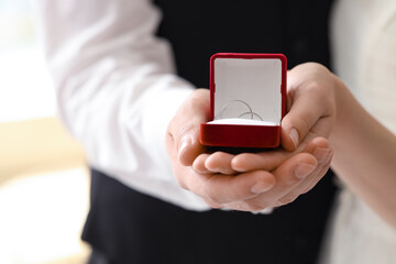 Young couple holding box with rings on their wedding day, closeup