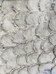 Unusual wall surface treatment with overlapping smears of weathered grey plaster abstract vertical background pattern