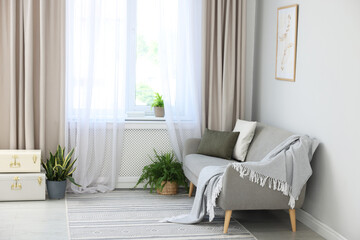 Comfortable sofa and elegant curtains in living room. Interior design