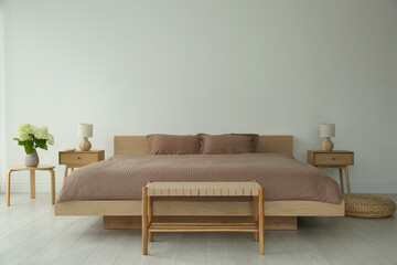 Stylish bedroom interior with comfortable big bed and lamps