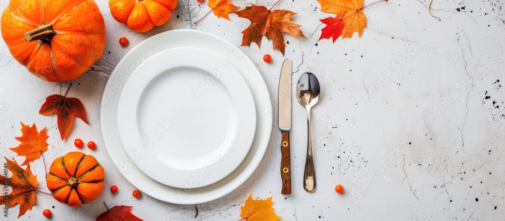 Poster autumn themed dinner table setting with pumpkins maple leaves plate knife and fork arranged for than