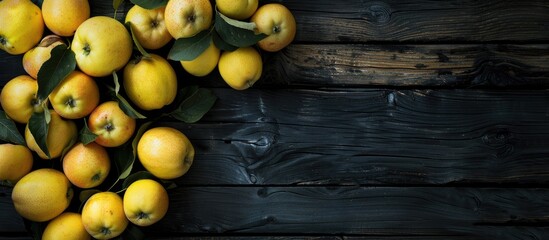 A dark wooden background offers copy space for vibrant yellow apples