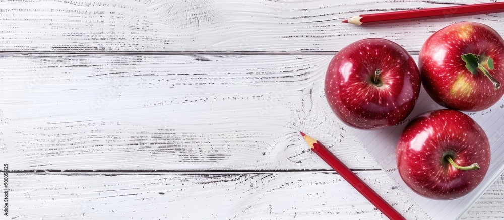 Poster Back to school concept with red apple and pencil placed on a notebook against a white wooden table background creating a composition perfect for a copy space image