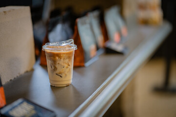 Close up and selective focus glass of ice latte on black table at coffee shop.