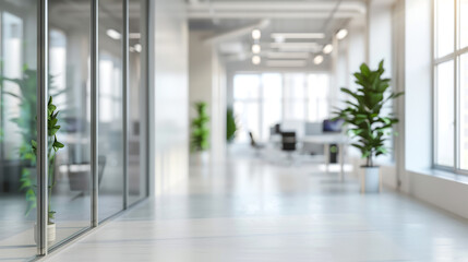 Blurred view of a modern office space with clean, white minimalistic decor and natural light streaming in through large windows.