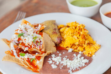 Huevo revuelto acompañado por Chilaquiles frijoles y un Tamal