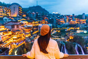 Young female tourist enjoying beautiful landscape at the Furong old Town, The famous tourist destination at Hunan Province, China