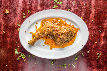 Chicken Leg Roast with fried onion and gravy served in bowl isolated on table background top view of bangladeshi, indian and pakistani food