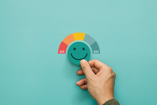 Service rating, satisfaction and positive feedback. A man choose smile face emoticon give a five star rating indicates the highest level of satisfaction with the service