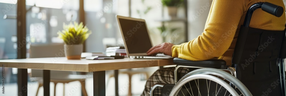 Aufkleber Person in a wheelchair working on a laptop at a desk with a plant. Emphasizing accessibility and inclusion in a professional workspace.