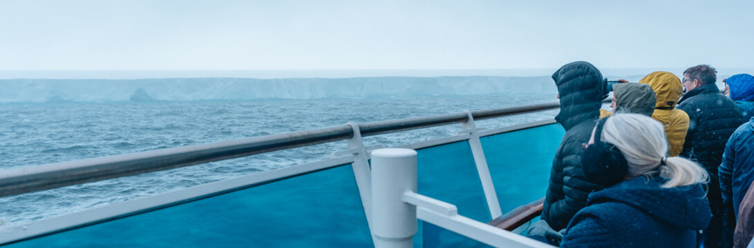 Antarctica - December 26th 2023 - Photo of A23a Iceberg from Cruise Ship Behind Crowd as it Snows. Passengers View and Photograph the Sight