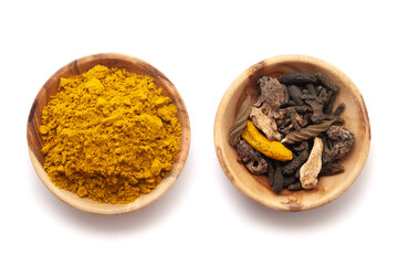 Top view of two wooden bowls, one filled with organic digestive powder known as 'buknu' and the second one filled with its whole spices.