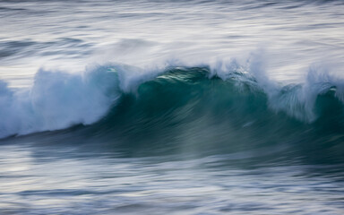 Obraz premium Motion of breaking wave at the beach.