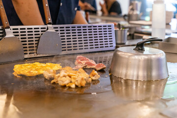The chef is stirring the delicious Teppanyaki chicken and the aroma is overwhelming