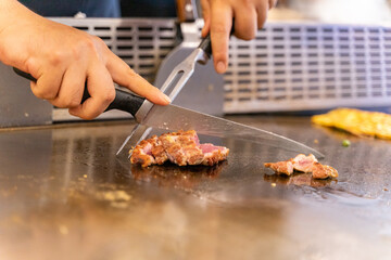 The chef is stirring the delicious Teppanyaki chicken and the aroma is overwhelming