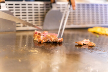 The chef is stirring the delicious Teppanyaki chicken and the aroma is overwhelming