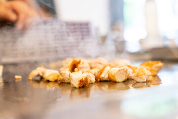 The chef is stirring the delicious Teppanyaki chicken and the aroma is overwhelming