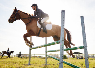 Equestrian, woman and horse jump for competition in the countryside with hurdle and jockey practice. Exercise, fitness and ranch with animal and athlete with trainer, stallion and hobby on field
