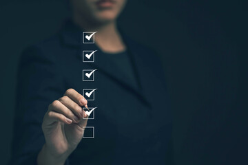 Business performance checklist concept Young business woman using laptop surveys online checklist Complete the digital form checklist via the internet..