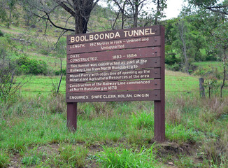 Information sign for the Boolboonda Tunnel with grass and trees near Mount Perry in Queensland, Australia