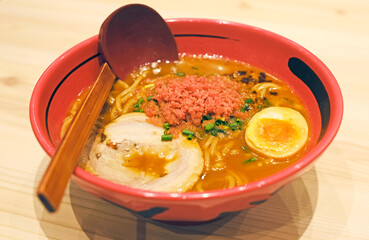 Japanese ramen noodles with pork, seaweed, soup in red bowl