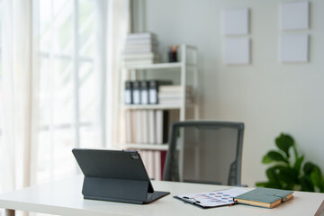 Stylish work area with laptop computer office supplies Files and books on shelves in the office Modern workplace concept.