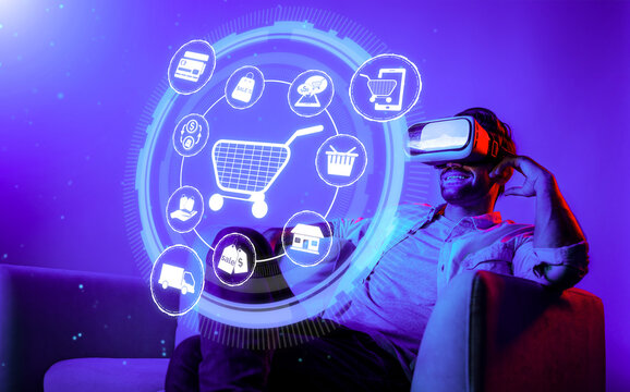 Happy man using VR headset and shopping online while sitting at sofa with shopping bags. Smart person looking at online market hologram and icon with neon background. Innovation technology. Deviation.