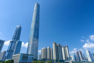 Fototapeta premium Skyscrapers Reaching into a Bright Blue Sky with White Clouds on a Sunny Day