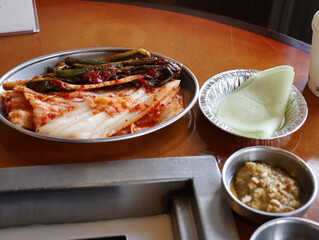 Traditional Korean green onion kimchi and condiments on a wooden table 
