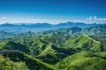 Obraz premium A picturesque scene of the Great Wall of China snaking through lush green mountains, under a clear blue sky