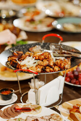 a large served festive table with appetizers. bowl of kebab stand in the center of the table.