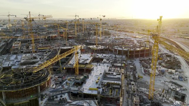 Drone view of Mega construction of Saudi Arabia on the sunset with plenty of cranes 