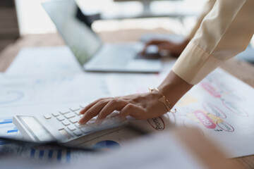 woman meticulously plans a finance audit, using a computer and calculator to review budget...