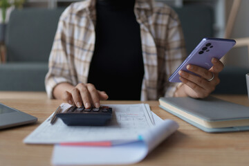 Fototapeta premium Smart Mortgage Planning woman using a calculator to make Calculations and Consideration
