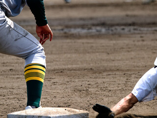 野球の試合で一塁へ帰塁のヘッドスライディングをする選手