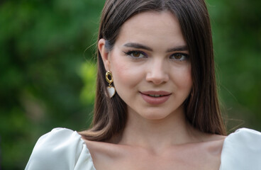 Fototapeta premium Portrait of a brunette girl outdoors in summer