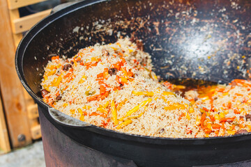 Uzbek pilaf cooked in a cauldron over a fire