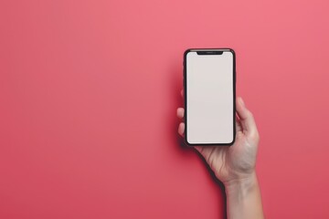 A hand holding a cell phone with a pink background