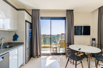 An open style kitchen next to a balcony and living room