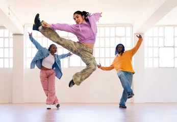 Papier peint photo YYoung group of multiethnic hip-hop dancers wearing colorful urban streetwear dancing - Stylish multiracial rap crew portrait in indoors dancing studio
