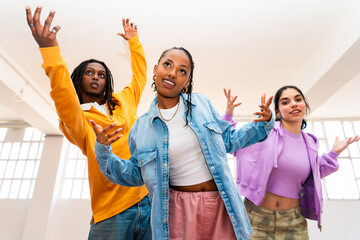 YYoung group of multiethnic hip-hop dancers wearing colorful urban streetwear dancing - Stylish...