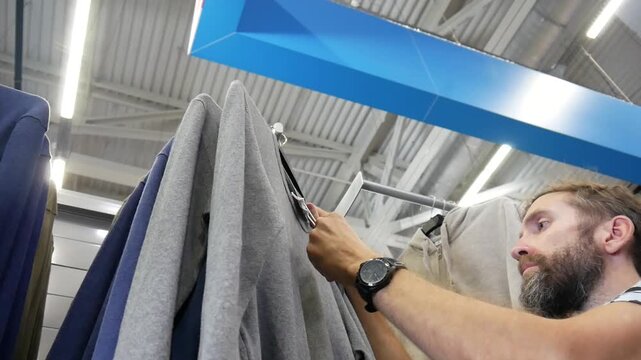 A male buyer choosing a pullover in a clothing store