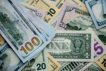 Big amount of US dollar bills in different nominations on table. Many dollar banknotes under natural light