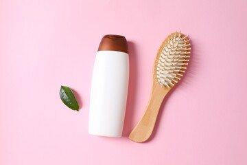 Shampoo with herbal extract and comb on color background, top view