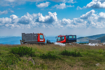 There are two tracked vehicles in the mountains © Adam