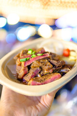 Grilled steak sliced on a plate with blurred background.
