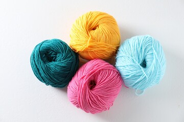 Many soft skeins of yarn on light grey background, flat lay