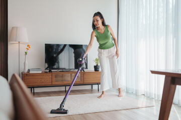 Adult woman vacuuming her living room. © eggeeggjiew